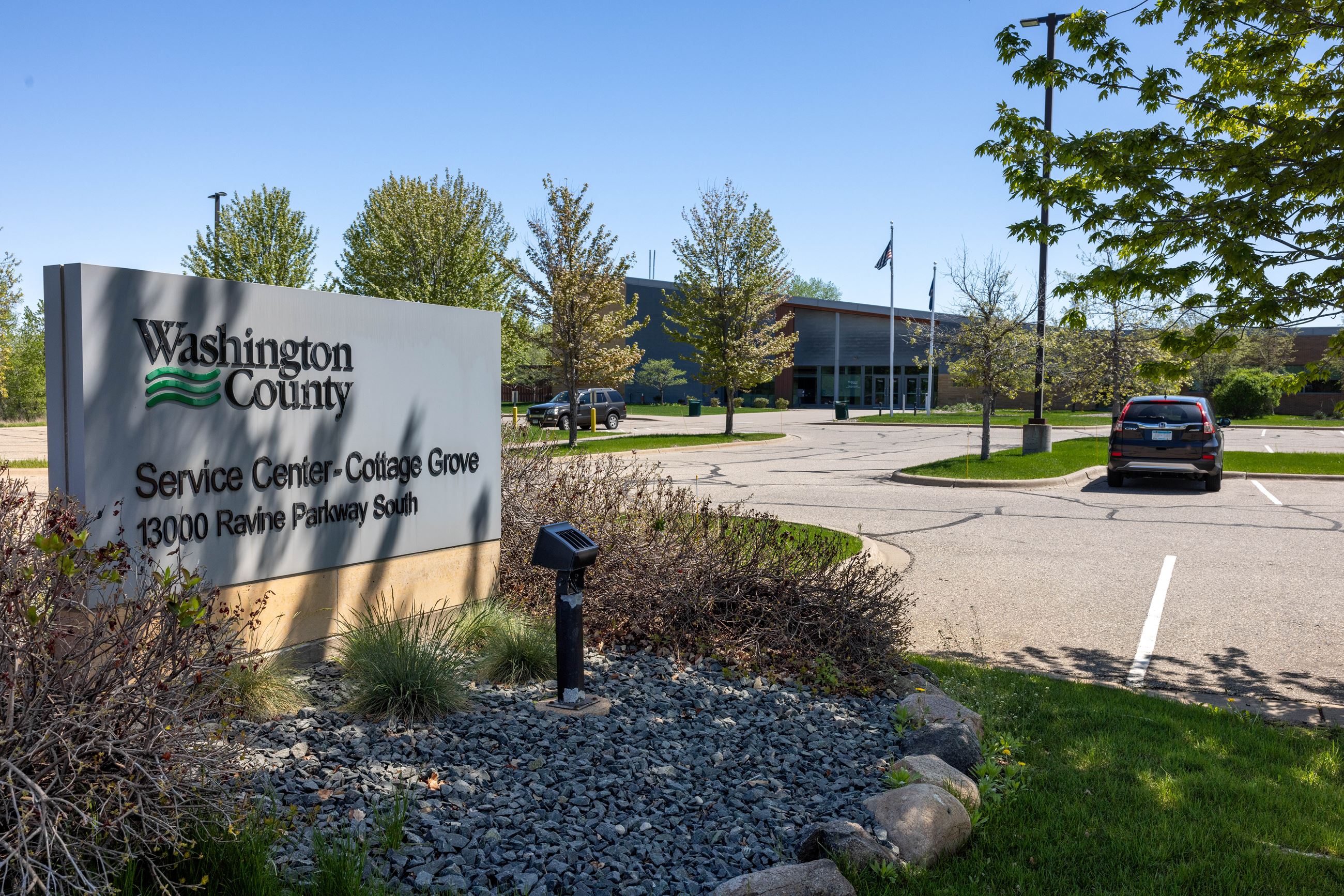 Sign that says Cottage Grove Service Center with a building in the background.